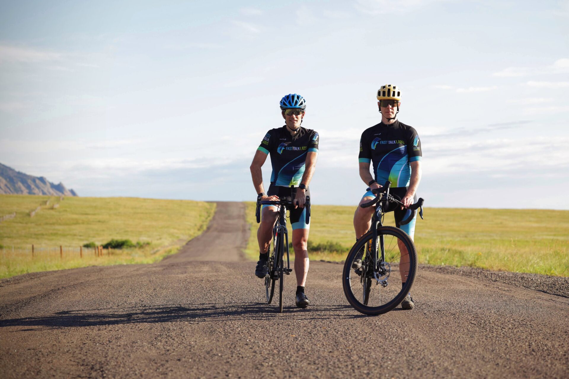 Rob Pickels and Trevor Connor standing with bikes on gravel roads in front of Flatirons Boulder